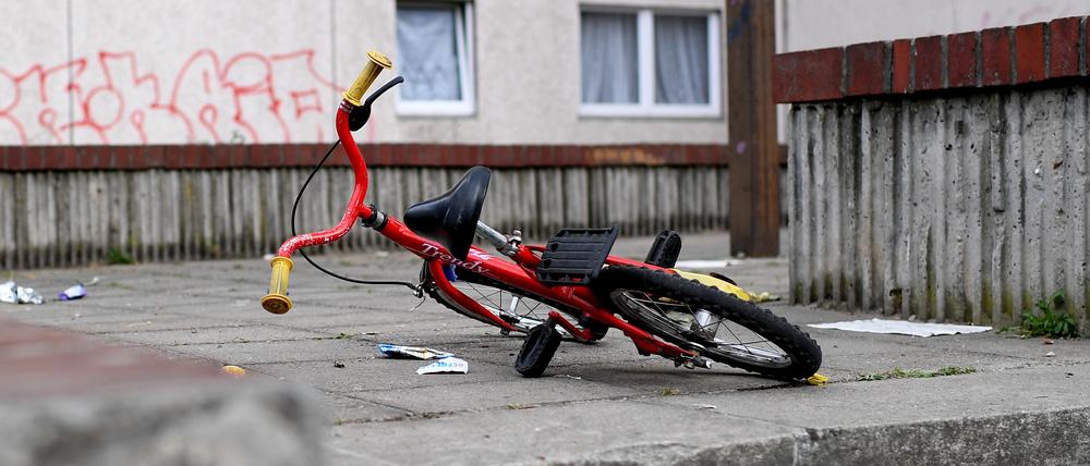 Ein Kinderfahrrad liegt in einem Aufgang zu einem Plattenbau.
