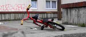 Ein Kinderfahrrad liegt in einem Aufgang zu einem Plattenbau.