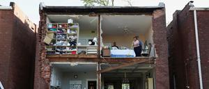 Bewohner sind in St. Louis in Missouri in einem Haus zu sehen, dessen Vorderfront ein Tornado weggefegt hat. 