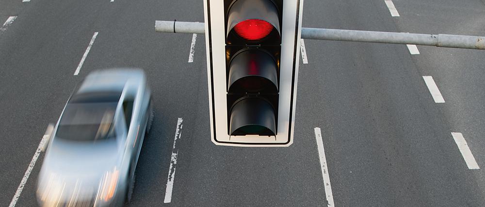 Ein Auto fährt an einer roten Ampel vorbei. (Symbolbild)