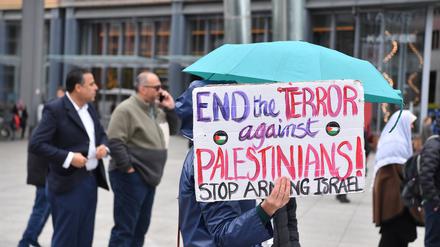 Eine Demonstrantin hält bei einer Propalästinensischen Demonstration auf dem Potsdamer Platz ein Schild hoch.