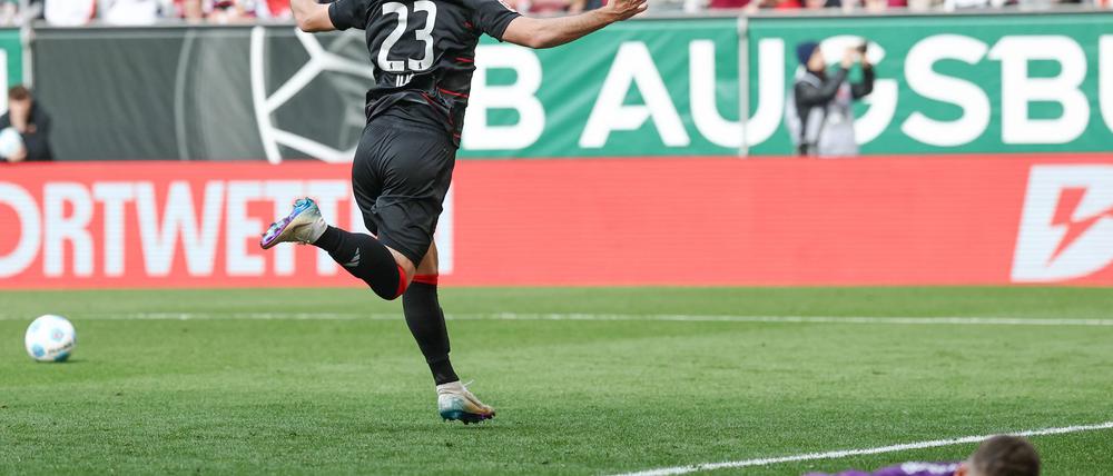 Berlins Matchwinner Andrej Ilic läuft nach seinem Siegtor jubelnd vor den Union-Fanblock. Augsburgs Torwart Finn Fahmen liegt geschlagen am Boden.