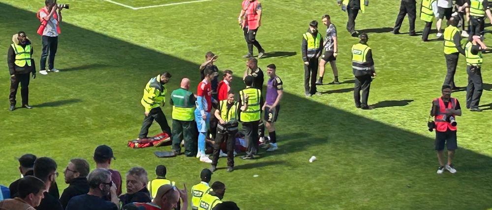 Jack MacKenzie von Aberdeen wird auf dem Spielfeld behandelt, nachdem er von einem Gegenstand getroffen wurde.