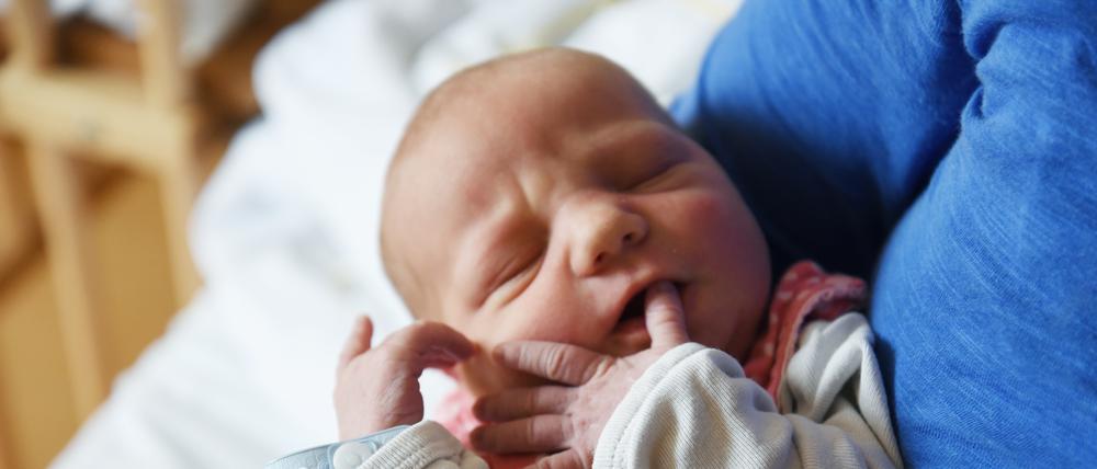Ein Neugeborenes auf dem Arm.