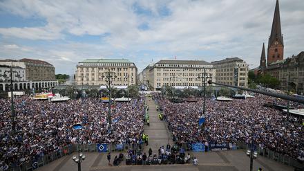 HSV-Fans stehen auf dem Rathausmarkt vor dem Hamburger Rathaus und feiern ihren Club.