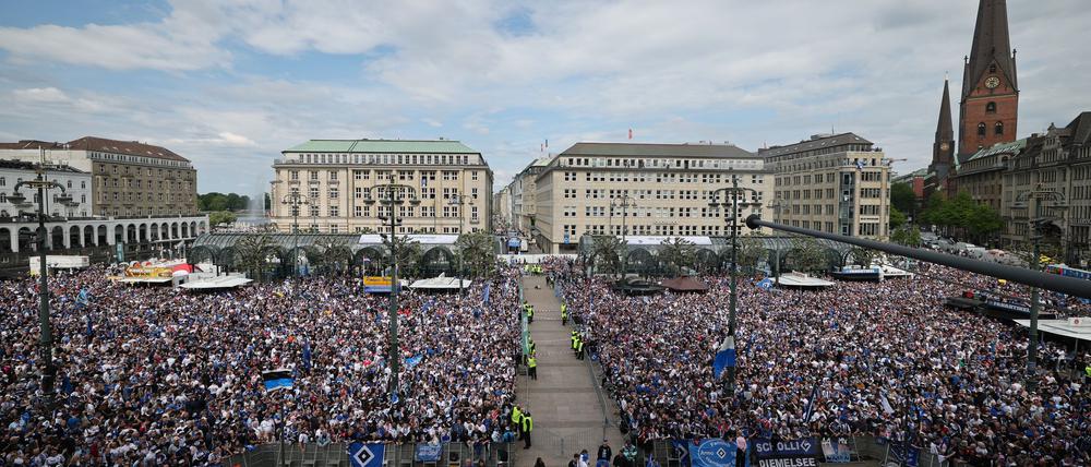 HSV-Fans stehen auf dem Rathausmarkt vor dem Hamburger Rathaus und feiern ihren Club.