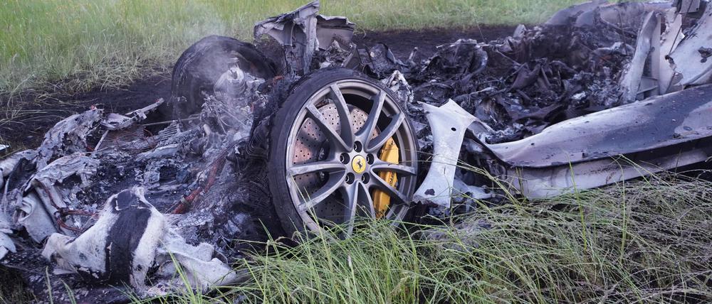 Die Überreste eines Sportwagens liegen nach einem Unfall an einem Feld.