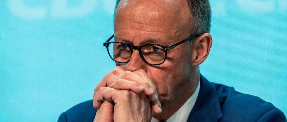 Bundeskanzler Friedrich Merz verschränkt auf einer CDU-Konferenz am 17. Mai in Stuttgart die Hände vor dem Gesicht.