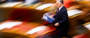 Der ungarische Regierungschef Viktor Orbán trägt auf dem Weg zur Abstimmung über den Rückzug aus dem IStGH Akten in seiner Hand.