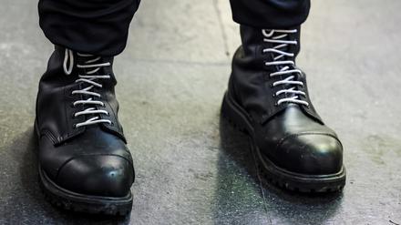 Ein Teilnehmer einer rechtsextremen Kundgebung trägt schwarze Springerstiefel mit weißen Schnürriemen, einem weit verbreiteten Symbol der rechten Szene. 