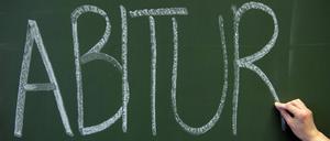 Auf einer Tafel wir das Wort Abitur mit weißer Kreide geschrieben.