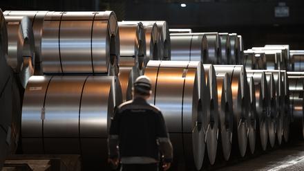 Ein Mitarbeiter von Thyssenkrupp läuft im Duisburger Werk vor Stahl-Coils entlang (Symbolbild).