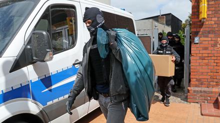 Razzia in Neubukow, Mecklenburg-Vorpommern: Nach Durchsuchungen von Räumen im Gebäude „Altes Postamt“ kommen die Ermittler mit beschlagnahmtem Material aus dem Haus. 