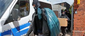 Razzia in Neubukow, Mecklenburg-Vorpommern: Nach Durchsuchungen von Räumen im Gebäude „Altes Postamt“ kommen die Ermittler mit beschlagnahmtem Material aus dem Haus. 