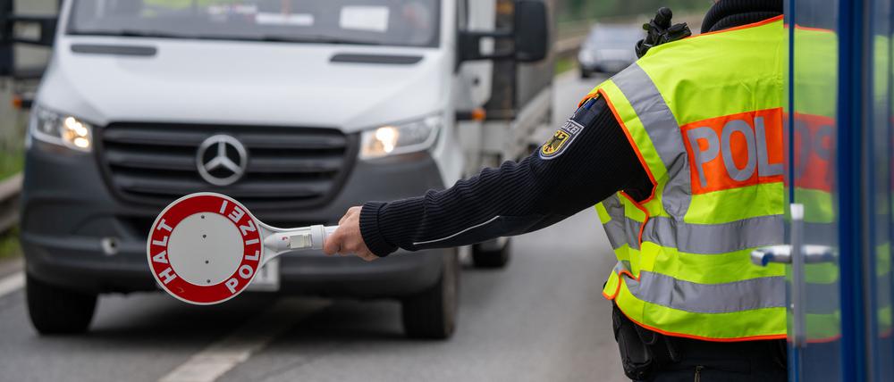 Ein Polizist hält einen Transporter auf der A64 bei Trier an (Symbolbild).