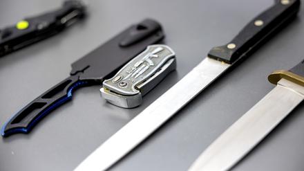 Auf einem Tisch liegen von der Polizei sichergestellte verbotene Stichwaffen. 