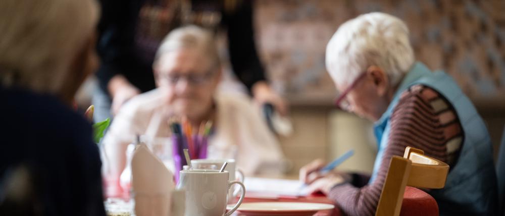 Bewohnerinnen eines Pflegeheims sitzen an einem Tisch.