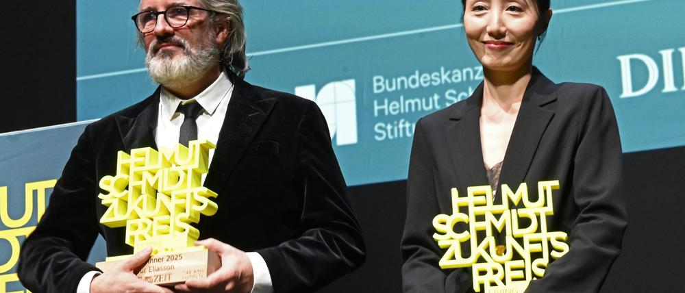 Olafur Eliasson und Hwanhee Hwang stehen mit dem Helmut-Schmidt-Zukunftspreis auf der Bühne im Hamburger Thalia Theater.