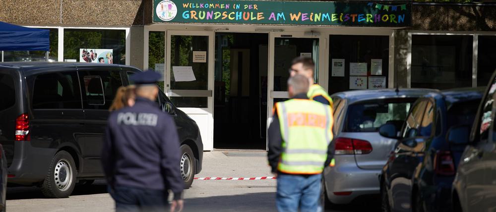 Polizisten stehen vor einer Schule im Berliner Bezirk Spandau, an der es am Vormittag einen möglichen Messerangriff auf einen Schüler gab.