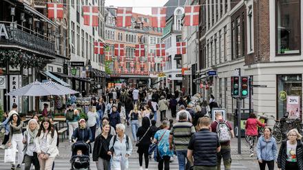 Menschen gehen in Kopenhagen durch eine Einkaufsstraße.
