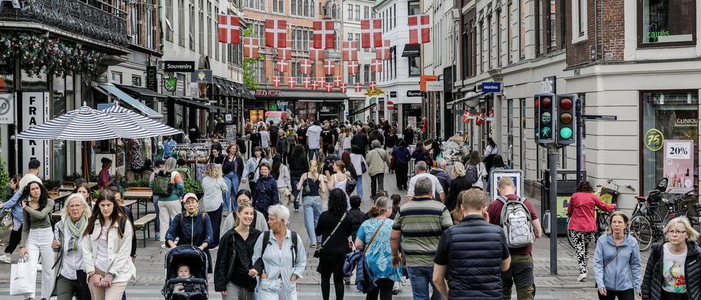 Menschen gehen in Kopenhagen durch eine Einkaufsstraße.