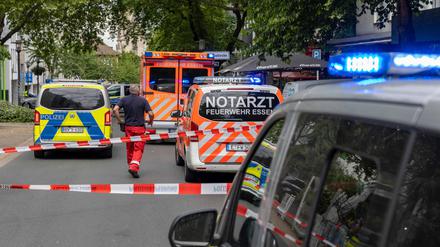 23.05.2025, Nordrhein-Westfalen, Essen: Einsatzfahrzeuge stehen auf einer Straße. Nach Schüssen in der Essener Innenstadt fahndet die Polizei mit einem Großaufgebot nach den geflohenen Tätern. 