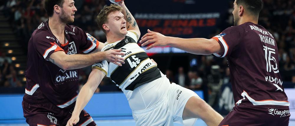 Kiels Emil Madsen (M) wird von Montpeliers Veron Nacinovic am Wurf gehindert.