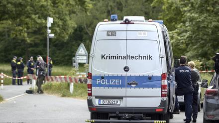 Einsatzkräfte der Polizei und Kriminaltechnik sind an einem Weg im Stadtteil Gropiusstadt im Bezirk Neukölln im Einsatz.