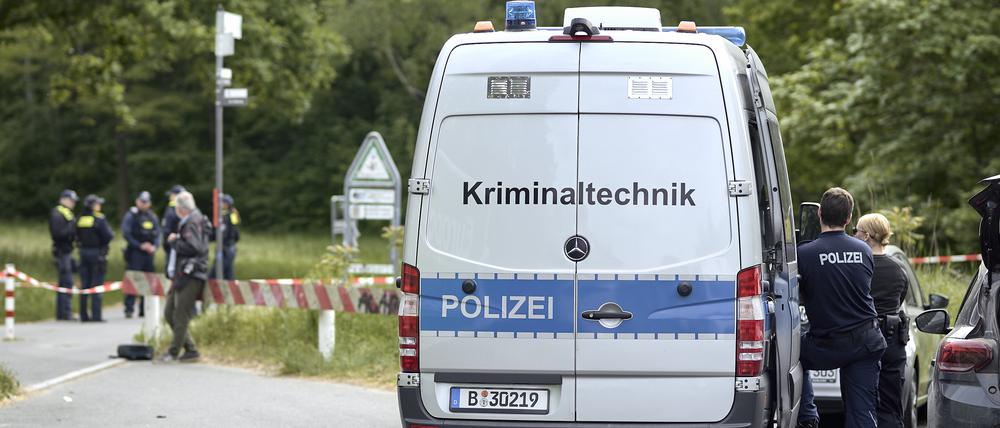 Einsatzkräfte der Polizei und Kriminaltechnik sind an einem Weg im Stadtteil Gropiusstadt im Bezirk Neukölln im Einsatz.