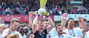 Trainer Dennis Kutrieb feiert mit seinen Spielern den Pokal.