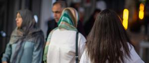 Eine Frau läuft in Teheran mit offenen Haaren am Abend eine Straße entlang (Symbolbild).