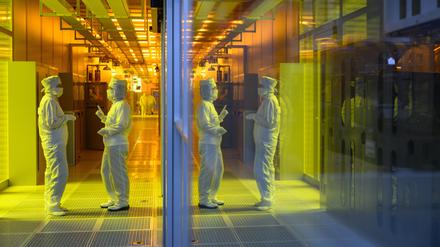 Mitarbeiterinnen des Chipkonzerns Infineon stehen im Reinraum der Chipfabrik. 