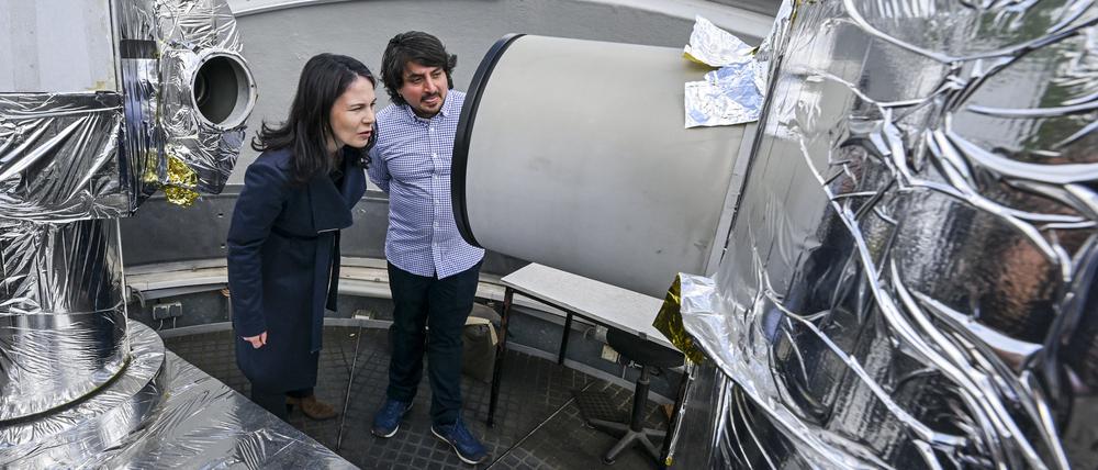 Annalena Baerbock (Grünen) lässt sich von Julian Rodriguez-Villamizar das Teleskop der Laserstation auf dem Potsdamer Telegrafenberg erklären.