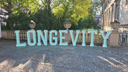 Ein Schriftzug „Longevity“ steht vor dem Schlosshotel in Grunewald.