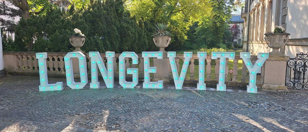 Ein Schriftzug „Longevity“ steht vor dem Schlosshotel in Grunewald.