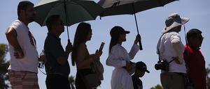 Las Vegas: Menschen tragen Regenschirme, um sich vor der Sonne zu schützen, während sie darauf warten, ein Foto am „Welcome to Las Vegas“-Schild zu machen.