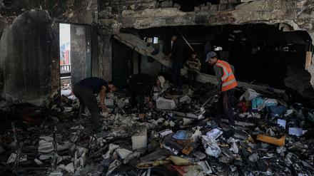 Palästinenser durchsuchen die Trümmer vor der Fahmi Al-Jarjawi-Schule nach einem israelischen Luftangriff in Gaza-Stadt. (Symbolfoto)