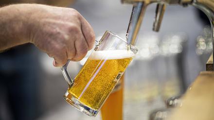 Ein Bier wird an einem Hahn gezapft.