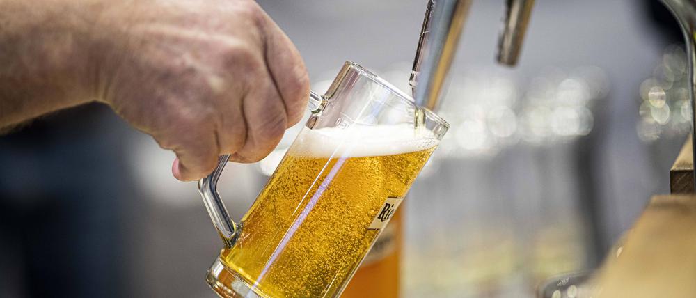 Ein Bier wird an einem Hahn gezapft.