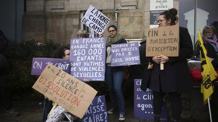 24.02.2025, Frankreich, Vannes: Ein Demonstrant hält ein Transparent mit der Aufschrift: «Schande wechselt die Seite», während eines Protests vor dem Gerichtsgebäude, in dem der Prozess gegen einen pensionierten Chirurgen beginnt. 