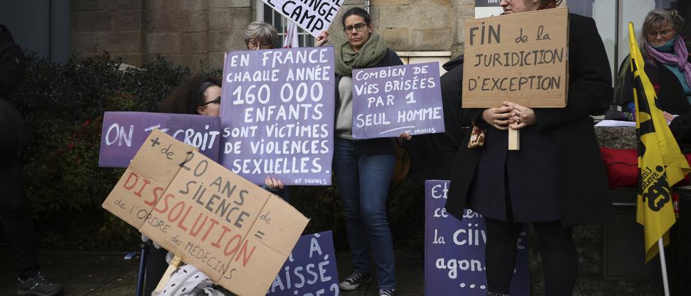24.02.2025, Frankreich, Vannes: Ein Demonstrant hält ein Transparent mit der Aufschrift: «Schande wechselt die Seite», während eines Protests vor dem Gerichtsgebäude, in dem der Prozess gegen einen pensionierten Chirurgen beginnt. 