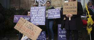 24.02.2025, Frankreich, Vannes: Ein Demonstrant hält ein Transparent mit der Aufschrift: «Schande wechselt die Seite», während eines Protests vor dem Gerichtsgebäude, in dem der Prozess gegen einen pensionierten Chirurgen beginnt.