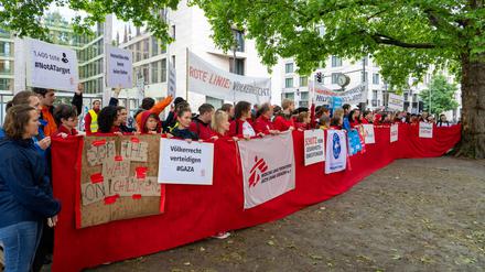 Mitarbeiter von Hilfsorganisationen demonstrieren in Berlin für mehr Hilfsgüter in Gaza.  