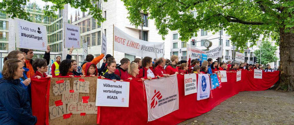 Mitarbeiter von Hilfsorganisationen demonstrieren in Berlin für mehr Hilfsgüter in Gaza.  