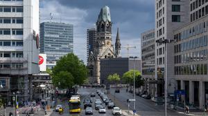 16.05.2025, Berlin: Dunkle Wolken ziehen hinter der von der Sonne beschienenen Kaiser-Wilhelm-Gedächtniskirche auf. Foto: Soeren Stache/dpa +++ dpa-Bildfunk +++