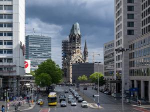 16.05.2025, Berlin: Dunkle Wolken ziehen hinter der von der Sonne beschienenen Kaiser-Wilhelm-Gedächtniskirche auf. Foto: Soeren Stache/dpa +++ dpa-Bildfunk +++