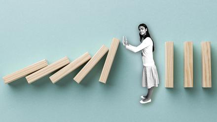 Illustration zum Thema „Grenzen setzen“: Eine Frau stoppt fallende Dominosteine.