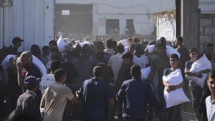 Palästinenser tragen Säcke mit Mehl, nachdem sie ein Lagerhaus des Welternährungsprogramms der Vereinten Nationen in Zawaida im zentralen Gazastreifen gestürmt haben.