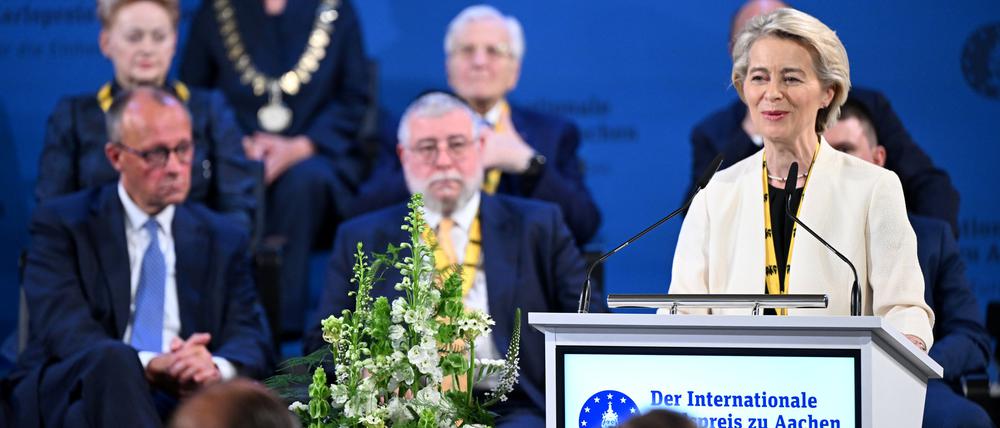 Ursula von der Leyen (r), Präsidentin der Europäischen Kommission, spricht nach der Verleihung des Internationalen Karlspreises im Rathaus - hinter ihr sitzen unter anderem Bundeskanzler Friedrich Merz (CDU, l) und Oberrabbiner Pinchas Goldschmidt (M), Karlspreisträger 2024.