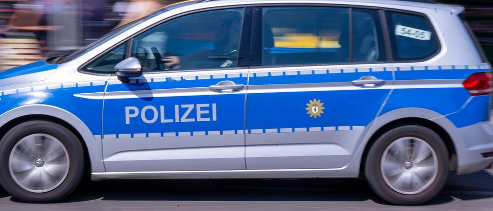 Ein Streifenwagen der Polizei fährt im Profil auf einer Straße vorbei. (Symbolbild)